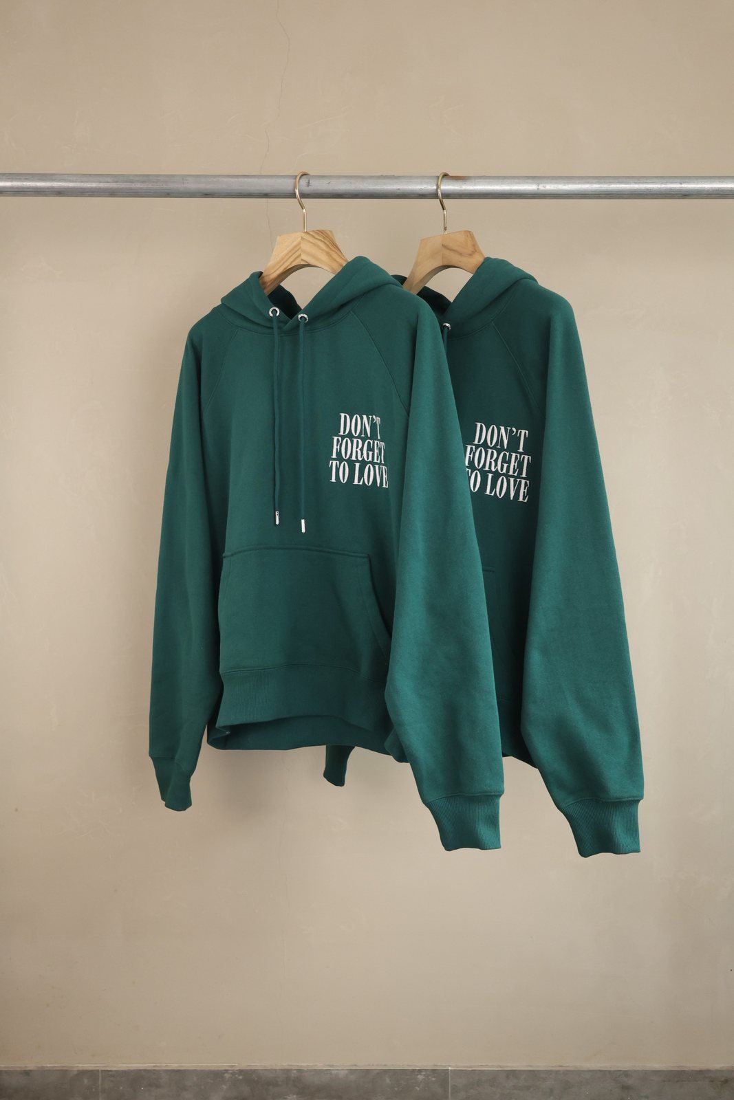 ami paris sweat vert sapin à capuche et inscription poitrine